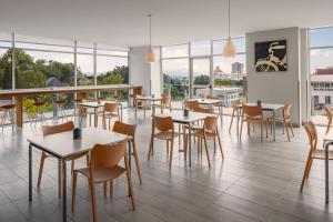 a restaurant with tables and chairs and windows at Element Asheville Downtown in Asheville