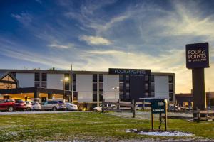 a building with cars parked in front of a parking lot at Four Points by Sheraton Allentown Lehigh Valley in Allentown