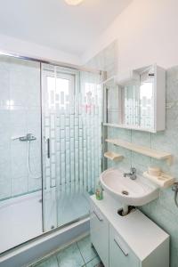 łazienka z umywalką i przeszkloną kabiną prysznicową w obiekcie Nice Apartment Silvia w Novalji