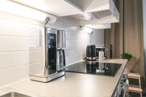 a kitchen with a microwave and a coffee maker at City Apartment Myllyntupa in Kuopio
