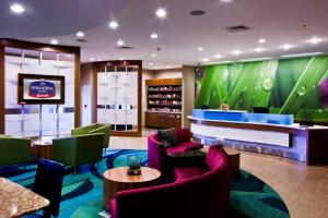 un vestíbulo de hotel con un bar con sillas moradas en SpringHill Suites by Marriott Mobile West, en Mobile