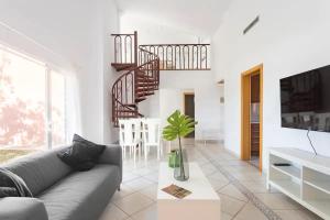 a living room with a couch and a staircase at Adosado La Guancha in San Miguel de Abona