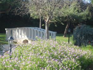 a white bridge in a garden with pink flowers at B&B Tenuta Martinelli in Monopoli