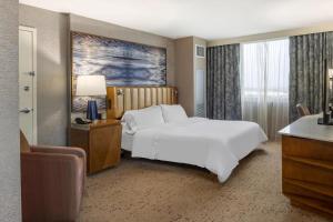 a bedroom with a large white bed and a desk at The Westin Fort Lauderdale in Fort Lauderdale