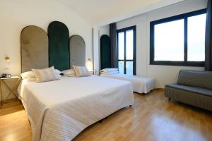 una camera d'albergo con due letti e una sedia di Art Hotel Milano a Prato