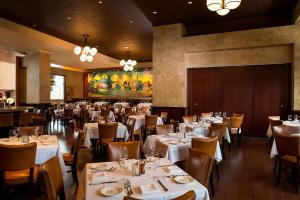 un comedor con mesas y sillas blancas en The Westin Buckhead Atlanta en Atlanta