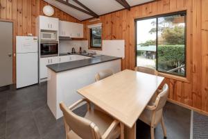 uma cozinha com mesa e cadeiras e uma janela em BIG4 Iluka on Freycinet em Coles Bay