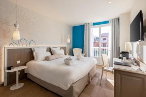 a hotel room with a large bed and a desk at Best Western Hotel Matisse in Sainte-Maxime +37 photos