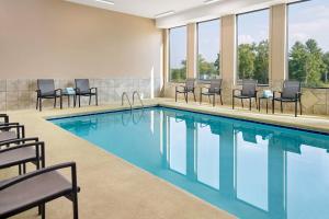 uma piscina com cadeiras, mesas e janelas em Fairfield Inn & Suites by Marriott Asheville Airport/Fletcher em Fletcher