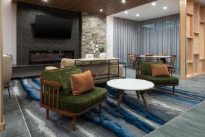 a living room with two chairs and a fireplace at Fairfield by Marriott Inn & Suites Dallas McKinney in McKinney