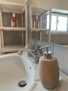 a bathroom sink with a soap dispenser on it at NO CEU - A fully private flat in the sky with Ocean view in Atouguia da Baleia