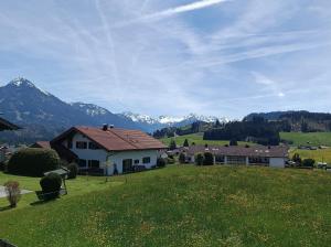 a house in a field with mountains in the background at Sonnenblick in Fischen