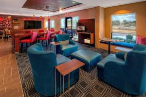 a waiting room with blue chairs and a bar at TownePlace Suites by Marriott Hattiesburg in Hattiesburg