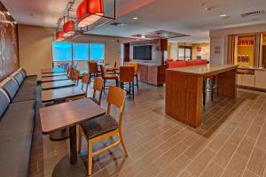 哈蒂斯堡的住宿－TownePlace Suites by Marriott Hattiesburg，一间带桌椅的餐厅和一间酒吧
