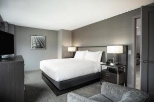 um quarto de hotel com uma cama e uma televisão em Residence Inn by Marriott Weehawken em Weehawken