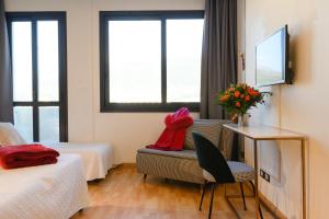 a hotel room with two beds and a table and a chair at Art Hotel Milano in Prato