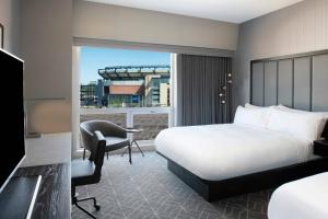 a hotel room with a bed and a desk and a window at Renaissance Boston Patriot Place Hotel in Foxborough