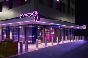a building with a neon sign on the side of it at Moxy Birmingham NEC in Bickenhill