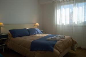 a bedroom with a bed with towels on it at BAHÍA NORTE.Tres ambientes con cochera a metros del mar in Mar del Plata
