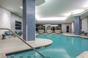 a pool in a hotel with chairs around it at Renaissance Boston Patriot Place Hotel in Foxborough