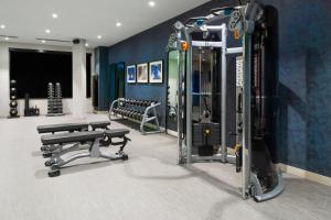 a gym with two treadmills and benches in a room at Renaissance Boston Patriot Place Hotel in Foxborough