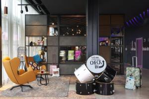 a room with chairs and a sign that says check in at Moxy Birmingham NEC in Bickenhill