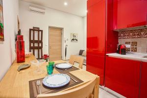 パレルモにあるKMC suites - Redのキッチン(木製テーブル、赤い冷蔵庫付)