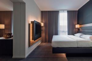 a bedroom with a bed and a flat screen tv at Moxy Copenhagen Sydhavnen in Copenhagen