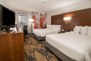 a hotel room with two beds and a flat screen tv at Fairfield Inn & Suites by Marriott Dallas DFW Airport South/Irving in Irving
