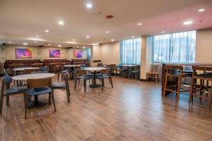 a dining room with tables and chairs and windows at Fairfield Inn & Suites by Marriott Dallas DFW Airport South/Irving in Irving