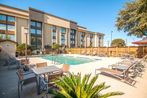 a hotel with a pool and tables and chairs at Fairfield Inn & Suites by Marriott Dallas DFW Airport South/Irving in Irving