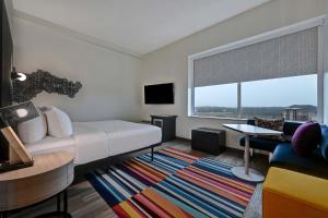 a hotel room with a bed and a large window at Aloft Mooresville in Mooresville