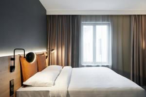 a bedroom with a large white bed with a window at Moxy Edinburgh Fountainbridge in Edinburgh