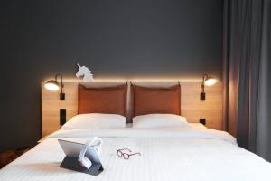 a bed with a laptop and a pair of shoes on it at Moxy Edinburgh Fountainbridge in Edinburgh
