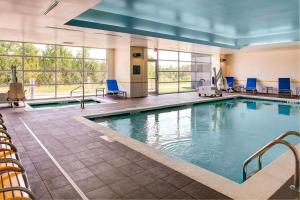 una piscina en una habitación de hotel con sillas azules en Fairfield Inn & Suites by Marriott Atlanta Stockbridge en Stockbridge