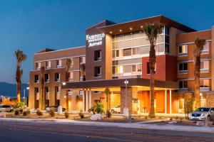 a hotel with palm trees in front of a building at Fairfield by Marriott Inn & Suites Palm Desert Coachella Valley in Palm Desert