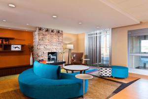 a living room with blue furniture and a fireplace at Fairfield by Marriott Inn & Suites Palm Desert Coachella Valley in Palm Desert