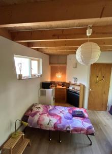 a large bed in a room with a kitchen at B&B 't Buitenkansje in Almere