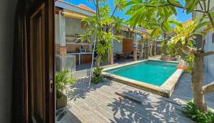 una piscina junto a una casa con patio en The Lavana Villa Sutji Sanur, en Sanur