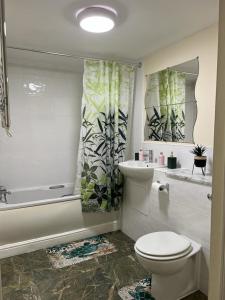 a bathroom with a toilet and a tub and a sink at Modern Spacious Gated Two Bedrooms Apartment in Stifford