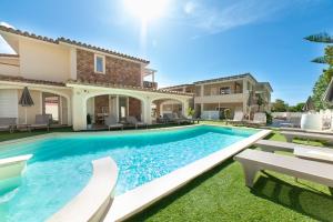 a swimming pool in front of a house at Suimi's Hotel in Villasimius