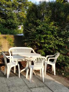 Sonnige EG_Wohnung mit Garten Terr في فورشهايم: طاولة نزهة بيضاء وكرسيين بجانب شجيرة