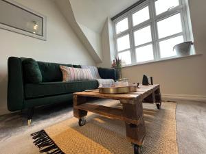 a living room with a green couch and a coffee table at Hidden Gem with Free Parking in Windsor
