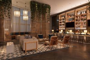 a hotel lobby with a bar and chairs and tables at Hotel Beaux Arts, Autograph Collection in Miami