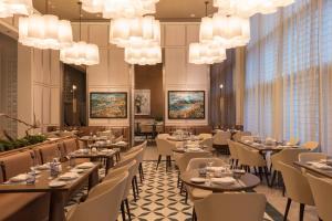 une salle à manger avec des tables, des chaises et des lustres dans l'établissement Hotel Beaux Arts, Autograph Collection, à Miami