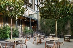 an outdoor patio with tables and chairs and trees at The Westin Istanbul Nisantasi in Istanbul