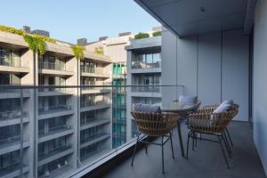 een balkon met een tafel en stoelen en een gebouw bij The Westin Istanbul Nisantasi in Istanbul