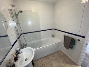 uma casa de banho com uma banheira, um lavatório e um chuveiro em Hidden Gem with Free Parking em Windsor
