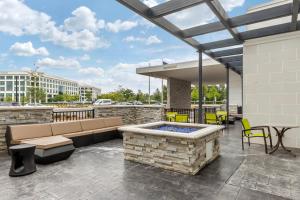 un patio con bañera de hidromasaje, mesa y sillas en SpringHill Suites Charlotte Southwest en Charlotte