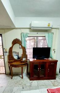 a room with a mirror and a tv on a table at Tientong Guesthouse in Hua Hin